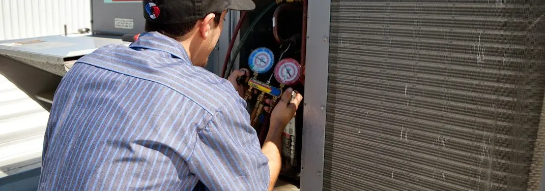 HVAC technician servicing a condenser unit in Elburn